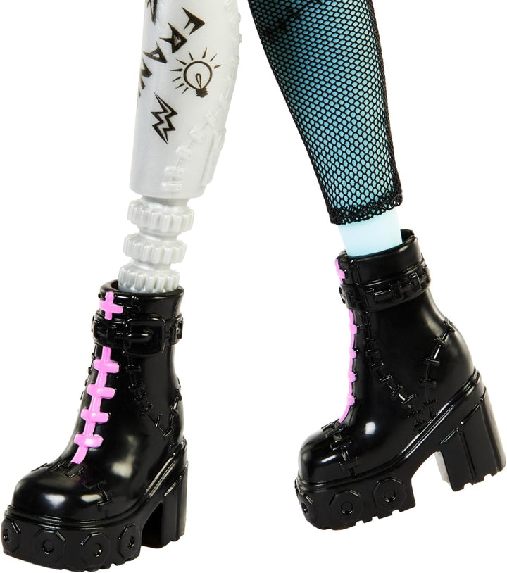 Păpușă Monster High Frankie Stone cu jachetă din denim și pantaloni scurți, include câinele Watzie și accesorii precum un rucsac, o gustare și un notebook, HXH73 Papusi Naty Shop